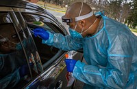 A U.S. Air Force Airman with the 108th Wing, New Jersey Air National Guard, prepares to take a nasal swab of a New Jersey Veterans Memorial Home at Vineland staff member during COVID-19 RT-PCR testing at the Home in Vineland N.J., Dec. 1, 2020. The test detects the live active virus for SARS-CoV-2, the virus that causes COVID-19. There are currently 26 New Jersey National Guard Soldiers and Airmen assisting at New Jersey’s three Veterans Memorial Homes, 10 are at Vineland. (New Jersey National Guard photo by Mark C. Olsen). Original public domain image from Flickr