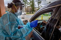 A U.S. Air Force Airman with the 108th Wing, New Jersey Air National Guard, prepares to take a nasal swab of a New Jersey Veterans Memorial Home at Vineland staff member during COVID-19 RT-PCR testing at the Home in Vineland N.J., Dec. 1, 2020. The test detects the live active virus for SARS-CoV-2, the virus that causes COVID-19. There are currently 26 New Jersey National Guard Soldiers and Airmen assisting at New Jersey’s three Veterans Memorial Homes, 10 are at Vineland. (New Jersey National Guard photo by Mark C. Olsen). Original public domain image from Flickr