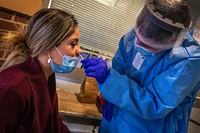 U.S. Army Pfc. Erick S. Alulema, combat medic specialist, Headquarters and Headquarters Troop, 102nd Cavalry Regiment, New Jersey Army National Guard, swabs the nose of a New Jersey Department of Military and Veterans Affairs employee during COVID-19 Ag testing at the New Jersey Veterans Memorial Home at Menlo Park in Edison, N.J., Dec. 9, 2020. The test detects the presence of protein antigens from SARS-CoV-2, the virus that causes COVID-19. There are currently 26 New Jersey National Guard Soldiers and Airmen assisting at New Jersey’s three Veterans Memorial Homes. (New Jersey National Guard photo by Mark C. Olsen). Original public domain image from Flickr