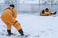 U.S. Air Force fire protection specialists assigned to the 673d Civil Engineer Squadron, use a safety line while practicing recovery techniques during ice rescue training at Six Mile Lake on Joint Base Elmendorf-Richardson, Alaska, Dec. 21, 2020. The training certified the firefighters as ice rescue technicians by providing them with the knowledge and skills necessary for safe rescue and recovery operations in ice and cold water. (U.S. Air Force photo by Airman 1st Class Emily Farnsworth). Original public domain image from Flickr