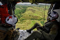 GUAM (August 24, 2020) Hospital Corpsman 3rd Class Storm Walker and Naval Aircrewman (Helicopter) 1st Class Jeffrey Jorgensen, assigned to the Island Knights of Helicopter Sea Combat Squadron 25, look out the starboard side door of an MH-60S Sea Hawk Helicopter.