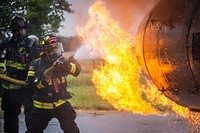New Jersey state fire protection specialists Albert Siu, right, and Joseph Collette with the New Jersey Air National Guard's 177th Fighter Wing extinguishes a simulated aircraft engine fire during live fire training at the Aircraft Rescue and Fire Fighting Training Center, Philadelphia International Airport, Pa., Sept. 18, 2020. The Atlantic City Air National Guard Base firefighters perform aircraft live fire training twice a year. The state-of-the-art facility is equipped with a simulator, which allows for interior and exterior training and an aircraft mock-up inside a propane fed pit. (New Jersey National Guard photo by Mark C. Olsen). Original public domain image from Flickr