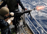 U.S. Navy Aviation Ordnanceman Airman Nicole M. Calvery fires an M-240B machine gun during a live-fire exercise aboard the forward-deployed amphibious assault ship USS Essex (LHD 2) Oct. 28, 2010, while under way in the Western Pacific Ocean.