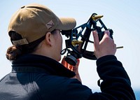 ATLANTIC OCEAN (April 27, 2021) Ensign Madysen Jaso, assigned to the Harpers Ferry-class dock landing ship USS Carter Hall (LSD 50), uses a sextant to measure the range of the fast combat support ship USNS Supply (T-AOE 6) during a replenishment-at-sea, April 26, 2021.