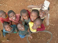 Young boys grouped together, looking at the Volunteer taking the photo. Original public domain image from Flickr