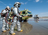 U.S. Marine firefighters with Marine Corps Air Station (MCAS) Yuma aircraft rescue and firefighting team stand ready to assist their counterparts from Marine Wing Support Squadron (MWSS) 471 during annual firefighter training at MCAS Yuma, Az., July 25, 2011.