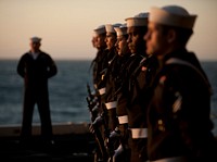 The rifle detail stands at parade rest during a burial at sea ceremony for 20 former service members aboard the Nimitz-class aircraft carrier USS Carl Vinson.