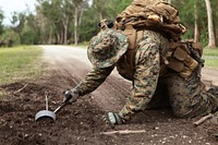 Careful. An explosive ordinance disposal Marine with Company A, Battalion Landing Team 1st Battalion, 4th Marines, 31st Marine Expeditionary Unit, inspects a possible improvised explosive device for wires and other components during the events of a mock boat raid on the Kin Blue training area.