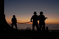 U.S. Sailors assigned to a fire fighting team aboard the guided missile frigate USS Ingraham (FFG 61) participate in an emergency flight quarters drill at sunset during Operation Martillo in the Pacific Ocean Feb. 14, 2012.