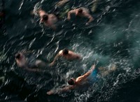 U.S. Sailors swim to the stern dock after jumping off aircraft elevator No. 4 during a swim call aboard the Nimitz-class aircraft carrier USS Carl Vinson (CVN 70) while under way in the Persian Gulf March 23, 2012.