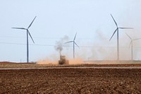 A tractor tills the soil among wind turbines in Oklahoma on August 13, 2009.