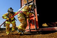 Members of the Afghan National Air Force fire department prepare to enter a storage container to practice firefighting during a drill July 18, 2012, at Kandahar Airfield, Afghanistan.