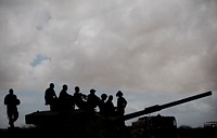Soldiers of the Kenyan Contingent serving with the African Union Mission in Somalia (AMISOM) are seen silhouetted against the sky while standing atop a tank in Saa&#39;moja. Original public domain image from <a href="https://www.flickr.com/photos/au_unistphotostream/8049898219/" target="_blank">Flickr</a>