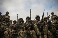 Troops from the Kenyan Contingent of the African Union Mission in Somalia (AMISOM) sit on the back of a flat-bed military truck as they form-up in the early morning ahead of an advance on the Somali port city of Kismayo.Kenyan AMISOM troops moved into and through Kismayo on 02 October 2012, the hitherto last major urban stronghold of the Al-Qaeda-affiliated extremist group Al Shabaab, on their way to the city's airport without a shot being fired following a month-long operation to liberate towns and villages across southern Somalia from Afmadow to Kismayo.