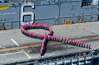 Amphibious assault ship USS Bonhomme Richard (LHD 6) floats in the South China Sea Oct. 14, 2012, as U.S. Sailors wearing pink shirts form up in the shape of a pink ribbon logo on the flight deck to show support for Breast Cancer Awareness Month during Amphibious Landing Exercise (PHIBLEX) 2013.