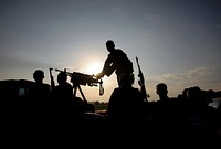 Soldiers of the Somali National Army (SNA) are silhouetted against the setting sun in the town of Jawahar in Middle Shabelle region 10 December 2010, north of the Somali capital Mogadisu.