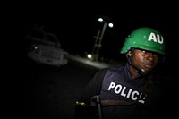 A Nigerian police officer serving with a Formed Police Unit (FPU) of the African Union Mission in Somalia (AMISOM) stands guard along a main street of the Somali capital Mogadishu during a joint night patrol and snap-vehicle checkpoint exercise with the Somali Police Force (SPF).