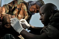 A Ugandan army dentist removes a rotten tooth from a patient at a medical outreach center in the Somali capital Mogadishu as part of the Tarehe Sita celebrations, which commemorates the formation of the modern-day Ugandan army, the Ugandan People's Defense Forces (UPDF) on 06 February 1981.