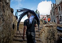 A Somali man carries a large sailfish on his head as he transports it to Mogadishu's fish market, Somali capital. Original public domain image from Flickr