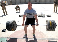 U.S. Army Sgt. Nicholas Wohlers, center, with Charlie Company, 702nd Brigade Support Battalion, attempts to set a new weight goal in the sumo deadlift event during the Dragoon Games hosted by the 4th Brigade Combat Team, 2nd Infantry Division at Kandahar Airfield in Kandahar province, Afghanistan, March 24, 2013.