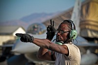 U.S. Air Force Airman First Class Darius Tillman, 455th Expeditionary Maintenance Squadron, marshalls an F-16C Fighting Falcon at Bagram Air Field, Afghanistan on Nov. 6. Tillman is a Virginia Air National Guardsman deployed from the 113th Fighter Wing. Original public domain image from Flickr