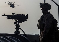 U.S. Marine Corps Lance Cpl. Matthew R. Nesbit, an infantry rifleman assigned to Lima Company, Battalion Landing Team (BLT) 3/2, 26th Marine Expeditionary Unit (MEU), stands guard while a CH-53E Super Stallion helicopter assigned to Marine Medium Tiltrotor Squadron (VMM) 266 (Reinforced), flies over the USS San Antonio (LPD 17), in the U.S. 5th Fleet area of responsibility, June 2, 2013.