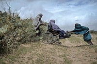 Two woman help another through a hedge of cacti at a food distribution center in Afgoye, Somalia, on August 4. The U.A.E Red Crescent gave out food aid as part of a program they are conducting during the month of Ramadan.