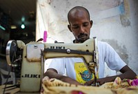 A tailor works on the street outside his shop in Hamar Weyne market in the Somali capital Mogadishu, 05 August, 2013.