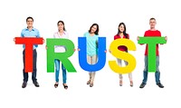 Multi-ethnic group of people holding "TRUST" letters