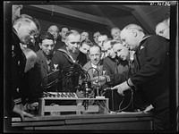 Coast Guard Auxiliary. Guardians of inland waters. Coast Guard Auxiliary members meet once a week for instruction. Here Harry Whitten, a Boston automobile distributor (right) gives instructions to fellow reservists in the workings of the ignition system of a marine engine. Sourced from the Library of Congress.