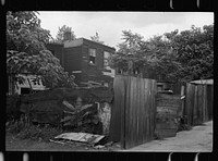 [Untitled photo, possibly related to: Front of home near Capitol, Washington, D.C. Interiors of these homes vary little. A chair or two and a table, a bed and perhaps an extra mattress on the floor cares for six to ten people]. Sourced from the Library of Congress.