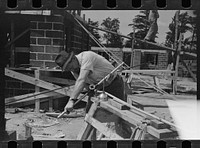 Plumber cutting pipe, Greenbelt, Maryland. Sourced from the Library of Congress.