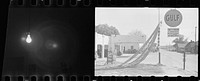 [Untitled photo: the first frame repeats USF33-001102-M4 (Gas station with trucker's quarters, Enfield, North Carolina) and a partial second frame shows a bare light bulb, lit and hanging from a cord]. Sourced from the Library of Congress.
