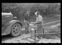 Truck driver picking up milk at Mrs. Howard's cut-over small farm. This is her main source of income. Aitkin County, Minnesota. Sourced from the Library of Congress.