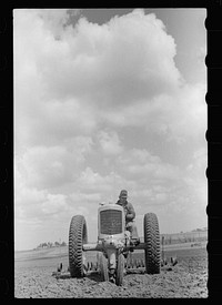 Farm boy operating tractor, Grundy County, Iowa. Sourced from the Library of Congress.