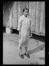 [Untitled photo, possibly related to: Daughter of sharecropper, Wilmington, North Carolina. Mother and another child in background]. Sourced from the Library of Congress.