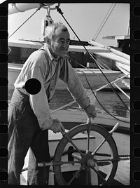 [Untitled photo, possibly related to: Oysterman at wheel of boat, Bivalve, New Jersey]. Sourced from the Library of Congress.