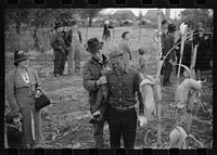 [Untitled photo, possibly related to: Contestant waits for starting gun as his wife and child look on, cornhusking contest, Marshall County, Iowa]. Sourced from the Library of Congress.