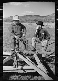 [Untitled photo, possibly related to: County supervisor George Stewart (right) discusses farm problems with rehabilitation client Russel D. Glenn in Chaffee County, Colorado]. Sourced from the Library of Congress.