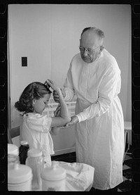 Doctor examines fractured arm, FSA (Farm Security Administration) camp clinic, Weslaco, Texas. Sourced from the Library of Congress.