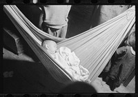 [Untitled photo, possibly related to: Baby asleep in hammock. The hammock saves space in a shack already overcrowded. Puerta de Tierra, San Juan, Puerto Rico]. Sourced from the Library of Congress.