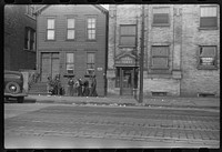 Street scene. The papers littering the sidewalk are "policy slips." Chicago, Illinois. Sourced from the Library of Congress.