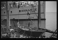 [Untitled photo, possibly related to: The economy of a town: fishing and the tourist trade. A fishing boat in front of the S.S. "Romance," a tourist boat which used to ply between Boston and Provincetown and has since sunk in Boston Harbor. Provincetown, Massachusetts]. Sourced from the Library of Congress.