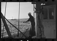 [Untitled photo, possibly related to: Aboard a trawler (locally called a dragger). The power-driven winch lets out the starboard net. While over fishing grounds one of two nets is constantly in the water, dragging along the bottom. Boats are powerful, diesel-engined, between forty and seventy-five feet long. Their unrestricted use has done much to cause the "fish-famine" along this coast because nets bring up everything, fish, minnows and even spawn. Provincetown, Massachusetts]. Sourced from the Library of Congress.