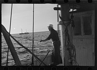 [Untitled photo, possibly related to: Aboard a trawler (locally called a dragger). The power-driven winch lets out the starboard net. While over fishing grounds one of two nets is constantly in the water, dragging along the bottom. Boats are powerful, diesel-engined, between forty and seventy-five feet long. Their unrestricted use has done much to cause the "fish-famine" along this coast because nets bring up everything, fish, minnows and even spawn. Provincetown, Massachusetts]. Sourced from the Library of Congress.