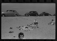 Beach scene at "New Beach," the most popular beach near Provincetown. Regular bus service makes this beach easily available; lack of bath houses causes a great deal of picturesque dressing and undressing in and behind parked cars. Provincetown, Massachusetts. Sourced from the Library of Congress.