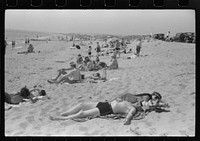 Beach scene at "New Beach," the most popular beach near Provincetown. Regular bus service makes this beach easily available; lack of bath houses causes a great deal of picturesque dressing and undressing in and behind parked cars. Provincetown, Massachusetts. Sourced from the Library of Congress.