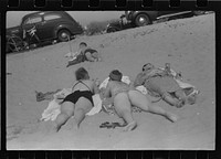 Beach scene at "New Beach," the most popular beach near Provincetown. Regular bus service makes this beach easily available; lack of bath houses causes a great deal of picturesque dressing and undressing in and behind parked cars. Provincetown, Massachusetts. Sourced from the Library of Congress.