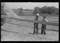 Two members of threshing crew standing by belt which supplies power for separator, central Ohio. One on left is Virgil Thaxton. Sourced from the Library of Congress.