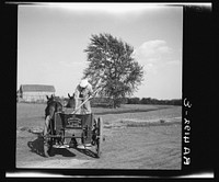 Rehabilitation client operating a lime spreader bought cooperatively through rehabilitation loan. Kansas. Sourced from the Library of Congress.